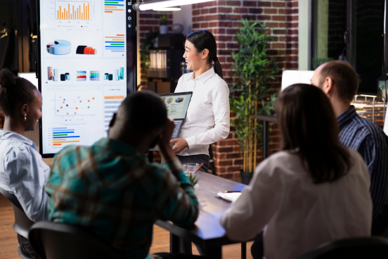 Group watching a person present charts and graphs